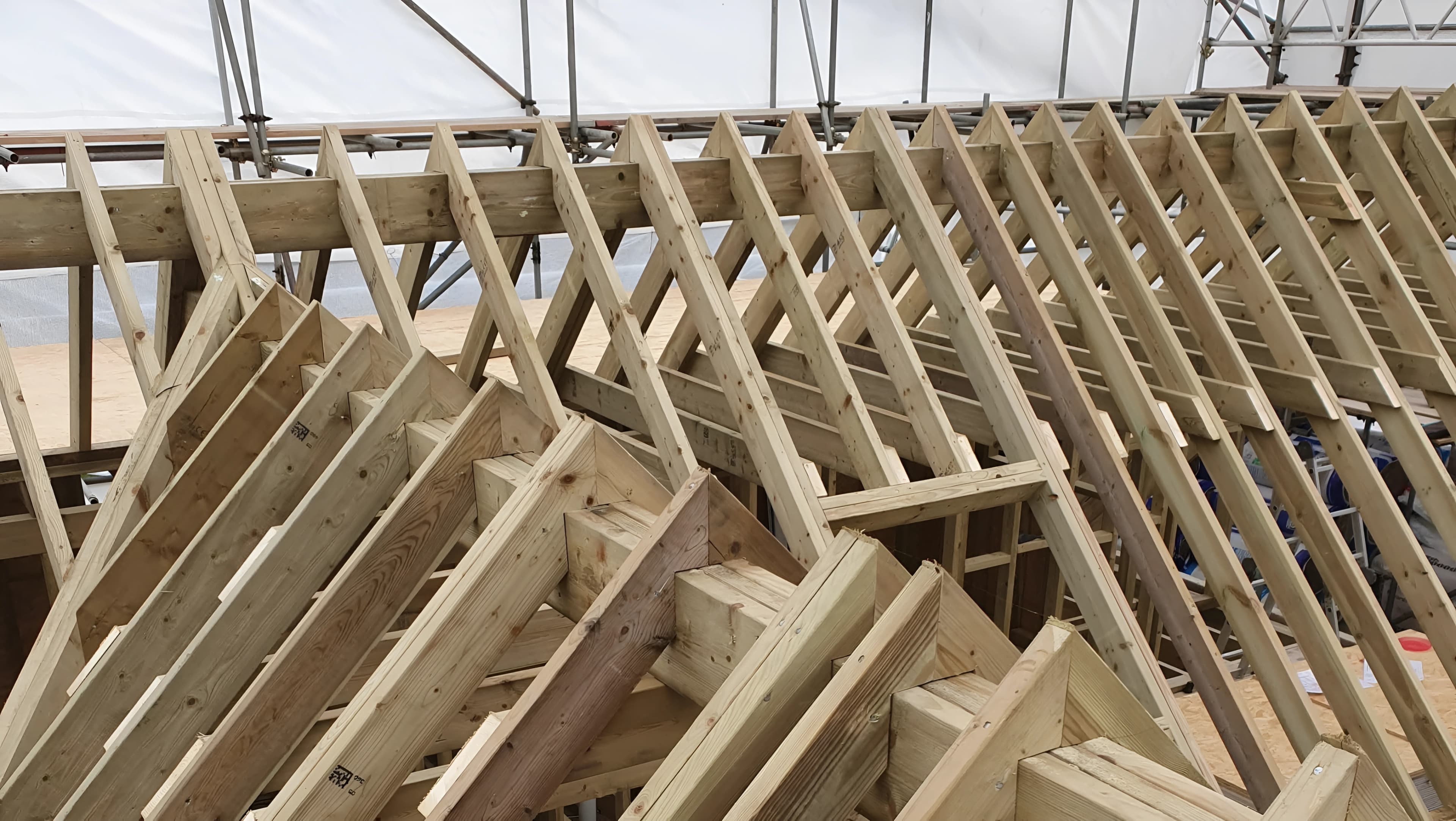 New roof trusses in place on a pitched roof